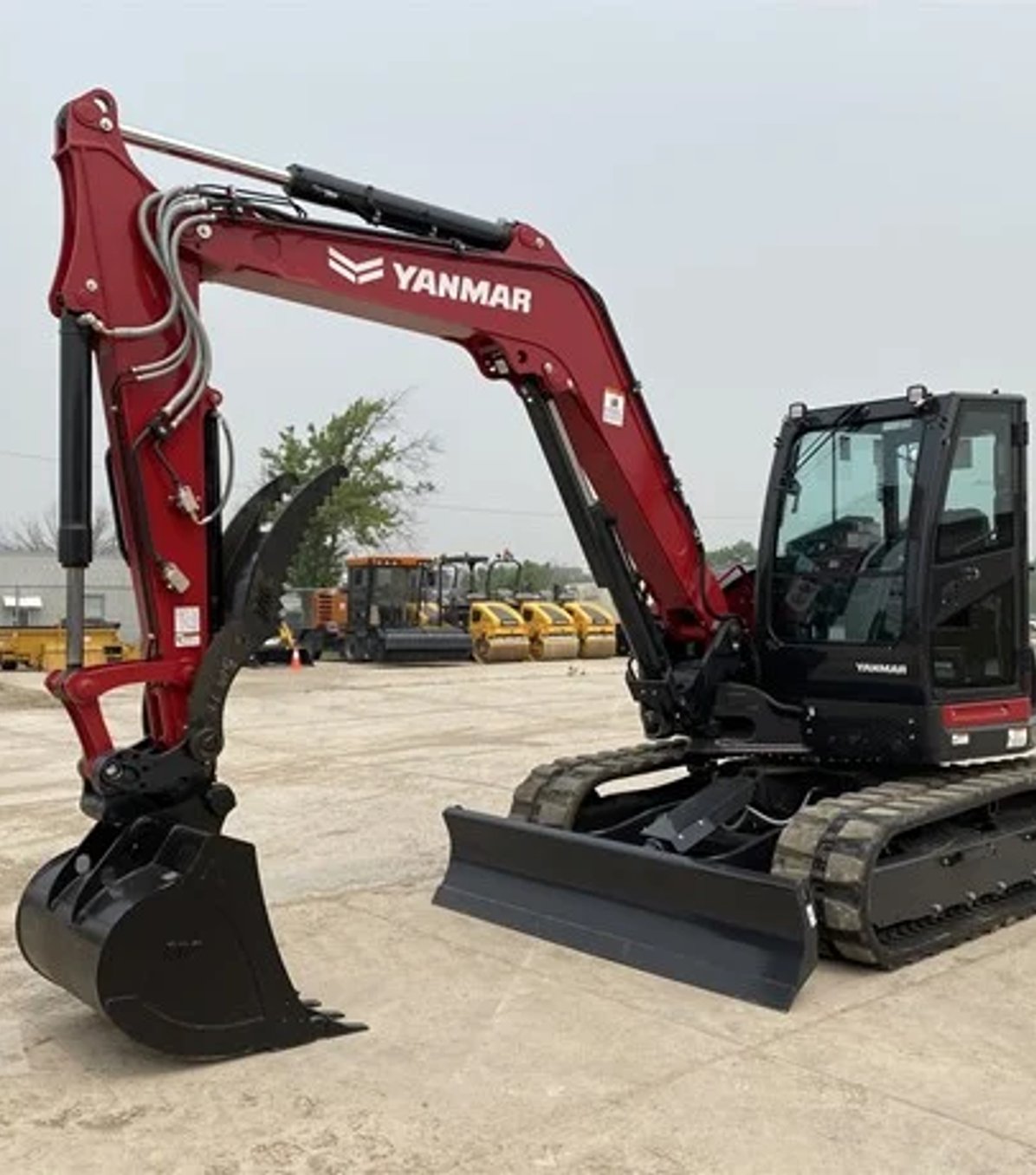 Yellow excavator with hydraulic breaker attachment at job site